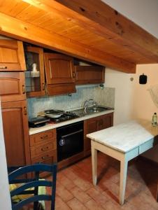 a kitchen with wooden cabinets and a table and a sink at VILLA CLAUDI b&b in Camerino