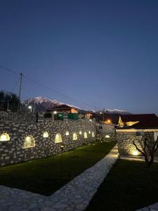 a stone wall at night with a blue sky at Mimani Stone House Roshnik in Roshnik
