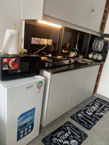 a kitchen with a microwave on top of a refrigerator at CozMila homes in Kiambu