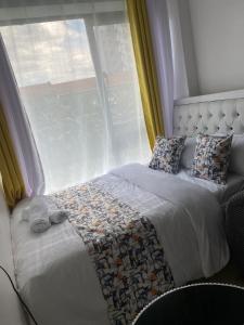 a bed in a bedroom with a window at CozMila homes in Kiambu