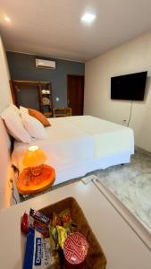 a hotel room with a bed and a table with snacks at VILA GAHERI Pousada Boutique com Piscina Privativa in São Miguel dos Milagres