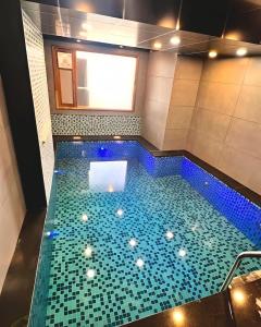 a swimming pool with blue tiles in a bathroom at Mokshada Hotel & Resort A Premium Property Near Jaypee in Mussoorie