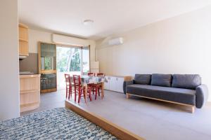 a living room with a couch and a table and chairs at IL TRITONE in Marina di Bibbona