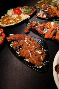 a table topped with different types of food on plates at Srushti Resort in Daulatābād