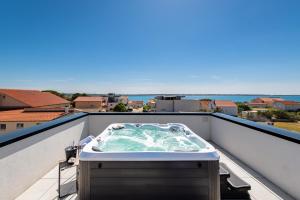 a hot tub on the roof of a balcony at Villa Restart Vrsi-Mulo with heated pool,sea view and jacuzzi in Vrsi
