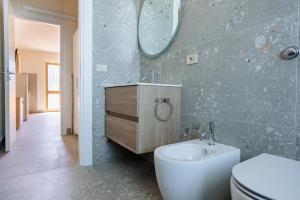a bathroom with a toilet and a sink and a mirror at IL TRITONE in Marina di Bibbona