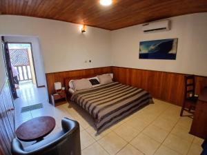a bedroom with a bed and a chair in it at Hotel Palm Rock Beach in San-Pédro +26 photos