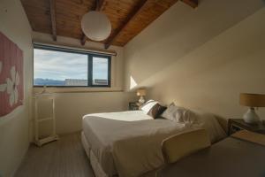 a bedroom with a bed and a large window at MINI LOFT Departamentos Bariloche in San Carlos de Bariloche +161 photos