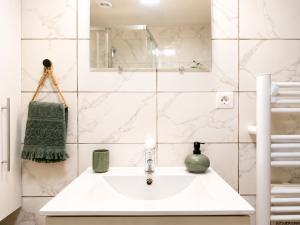 a white bathroom with a sink and a mirror at " Loutrein Lodge " Centre ville - Entrée autonome - Wifi in Saint-Girons +12 photos