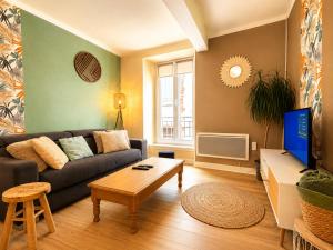 a living room with a couch and a tv at " Loutrein Lodge " Centre ville - Entrée autonome - Wifi in Saint-Girons