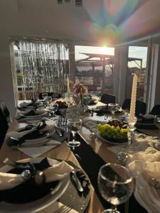 a long table with plates of food and wine glasses at Domki u Duszy Wielka Dusza in Brenna