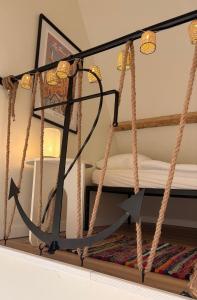 a boat hanging from ropes in a room at L'Échappée iodée à "La Cahute" - Rénovée, Calme & Proche Mer in Ambleteuse +12 photos