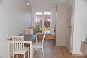 a kitchen with a table and chairs and a window at Erdvūs apartamentai Prie Jūros in Melnragė +11 photos