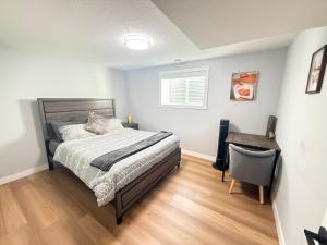 a bedroom with a bed and a chair in it at 2 bedroom Cozy Secondary-Basement suite in Calgary