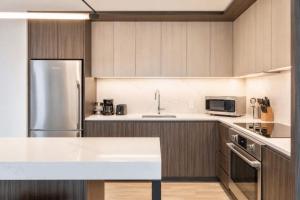 a kitchen with a white counter top and a refrigerator at Luxury Seaport Stay Rooftop & Pool in Boston +18 photos