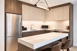 a kitchen with a stainless steel refrigerator and cabinets at Luxury Seaport Stay Rooftop & Pool in Boston