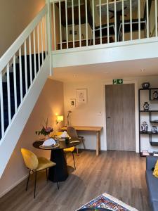 a living room with a staircase and a table and chairs at Schuringse Klasse in Numansdorp