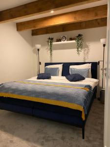 a bedroom with a blue bed with two pillows at Schuringse Klasse in Numansdorp