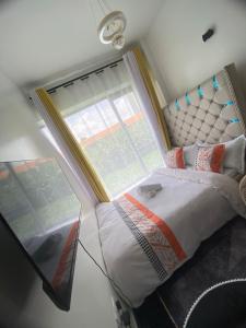 a bedroom with a bed with a large window at CozMila homes in Kiambu