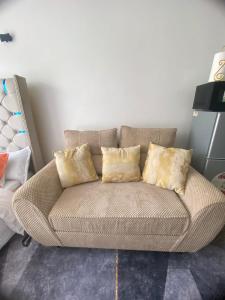 a couch with three pillows on it in a room at CozMila homes in Kiambu