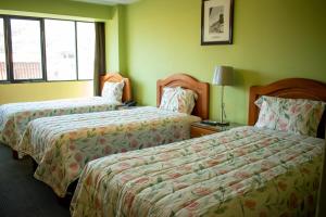 ein Hotelzimmer mit zwei Betten und einem Fenster in der Unterkunft Hotel Sucali in Huaraz + 4 Fotos