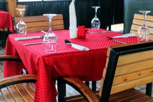 ein Tisch mit roter Tischdecke und Weingläsern in der Unterkunft Kitabi EcoCenter in Kitabi