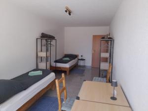 a room with two beds and a table and shelves at Ferienhaus Traumblick-Neustadt in Neustadt an der Weinstraße
