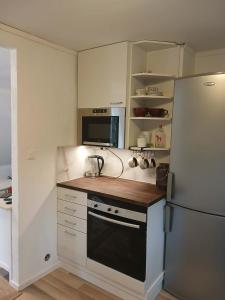 a kitchen with white cabinets and a refrigerator at Berghaga in Köping
