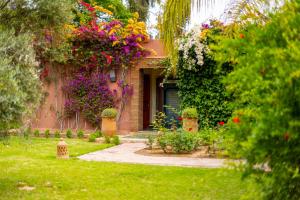 a house with flowers on the side of it at Mila Dyafa in Oulad Akkou