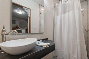 a bathroom with a white sink and a shower at Library INN - Boutique Rooms - Free Breakfast - Hot Tub in Lava Hot Springs +21 photos