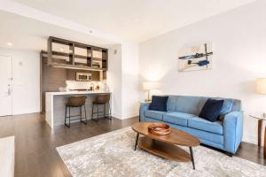 a living room with a blue couch and a table at Luxury Apt with Gym & Pool in New York