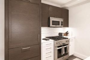 a kitchen with a stove and a microwave at Luxury Apt with Gym & Pool in New York