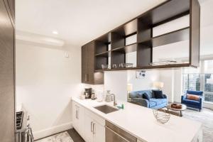 a kitchen with a sink and a blue couch at Luxury Apt with Gym & Pool in New York