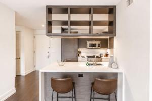 a kitchen with a counter with chairs in it at Luxury Apt with Gym & Pool in New York