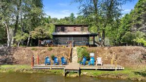 a group of chairs sitting on a dock in the water at A Rivers Edge in Mineral Bluff