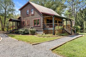 a log cabin with a porch and a walkway at A Rivers Edge in Mineral Bluff