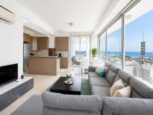 a living room with a couch and a large window at TOP RATED - PREMIUM Seaview 2-BDR-Apt in tallest building in Larnaca - 2 min Walk to Beach in Larnaca