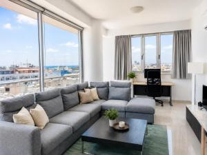 a living room with a couch and large windows at TOP RATED - PREMIUM Seaview 2-BDR-Apt in tallest building in Larnaca - 2 min Walk to Beach in Larnaca