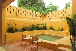 a pool in a fence with two chairs and a table at Kuka y Letras in Mérida