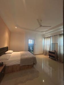 a bedroom with a bed and a ceiling fan at Fawis Lodge in Brusubi