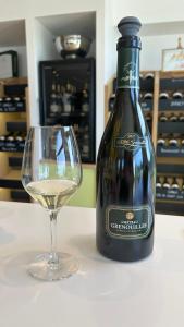 a bottle of white wine next to a glass at Maisons Vaudésir - Rose, Chablis in Chablis