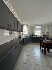 a large kitchen with a table and a dining room at Fawis Lodge in Brusubi