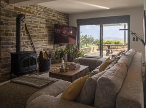 a living room with a couch and a fireplace at Astraea Villa in Karistos