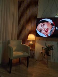 a living room with a chair and a tv at PANDORA BULEVAR Cacak in Čačak