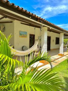 a house with a hammock in front of it at Pousada em Paracuru Casa Eco Kite Surf & Relax in Paracuru
