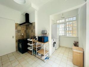 a kitchen with a refrigerator and a tiled floor at Lx Factory Apartment-Lisbon Style-Spacious & Bright-Congress Centre in Lisbon