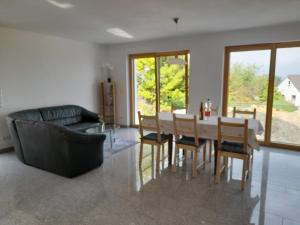 a living room with a table and chairs and a couch at Ferienhaus Traumblick-Neustadt in Neustadt an der Weinstraße