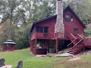 a red house with a porch and a chimney at Bigfoots River Retreat in Mineral Bluff