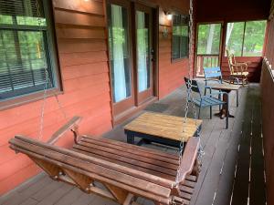 a porch swing on the front of a house at Bigfoots River Retreat in Mineral Bluff