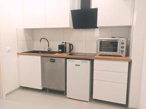 a kitchen with a counter with a microwave and a refrigerator at Chez Alice 1 in Montbéliard